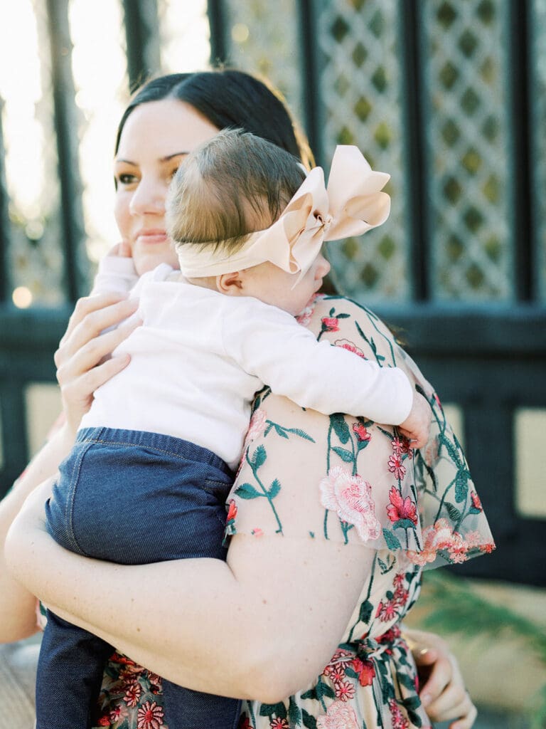 A mother smiling while holding her baby by Katie Stansfield Photography, a Virginia family photographer.