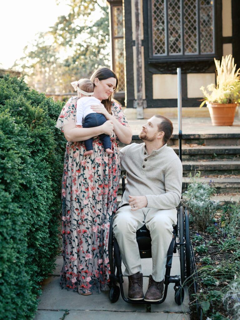 A couple smiling at each other as the mom holds their baby at Agecroft Hall and Gardens, one of the best locations for Richmond fall family photos by Katie Stansfield Photography.