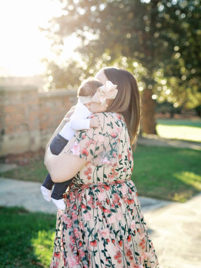 A mom hugging her baby at Agecroft Hall and Gardens, one of the best locations for Richmond fall family photos by Katie Stansfield Photography.