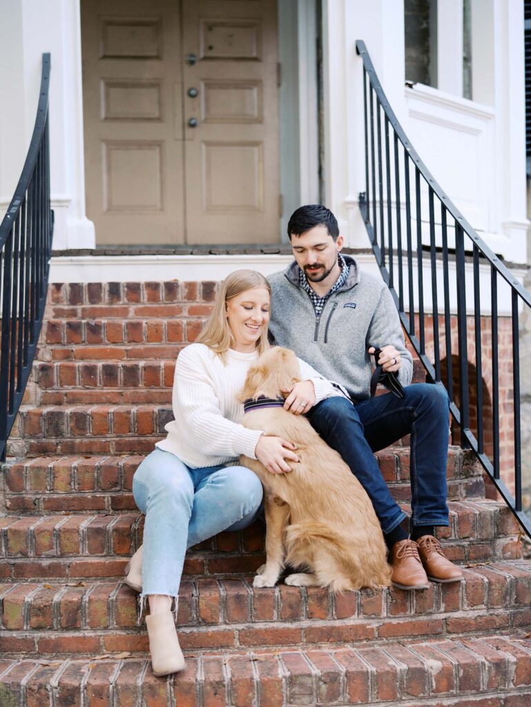 A couple looking at their dog at a family photography session at Forest Hill Park in Richmond, VA by Katie Stansfield Photography.
