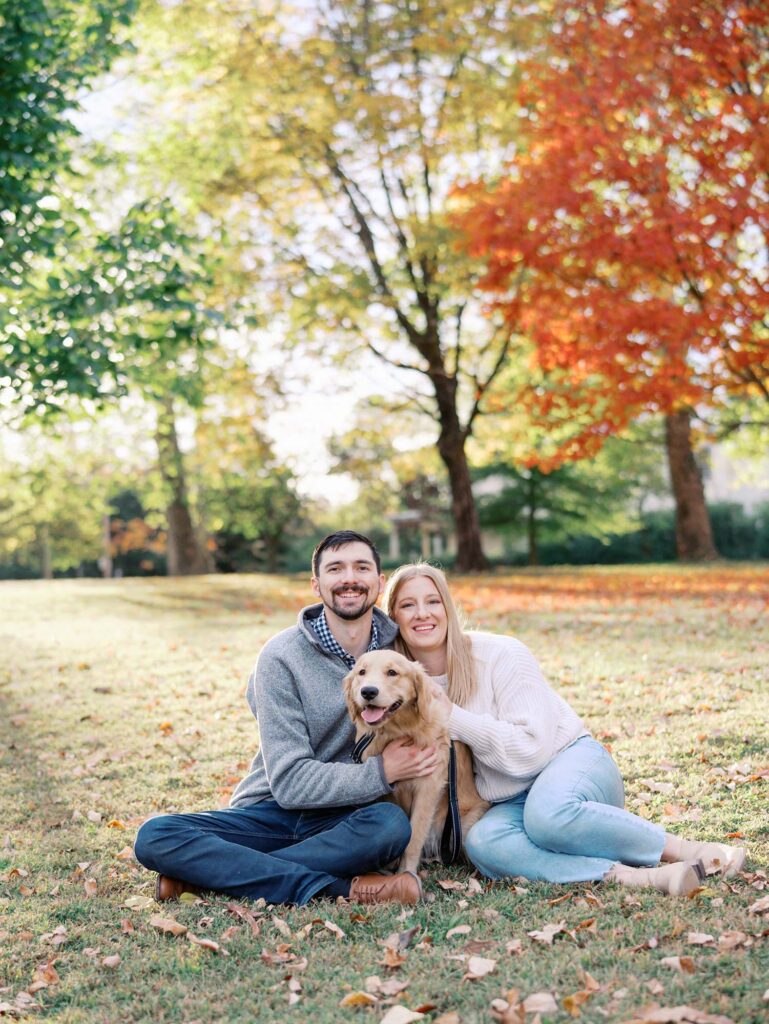 A couple with their dog surrounded by fall foliage at Forest Hill Park, one of the best locations for Richmond fall family photos, by Katie Stansfield Photography.