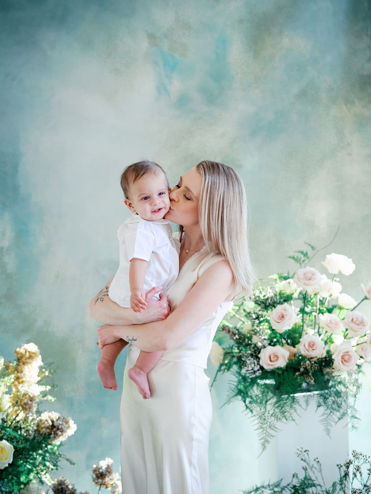 A mom holding her baby dressed in cute baby clothes in Richmond, Virginia by Katie Stansfield Photography.