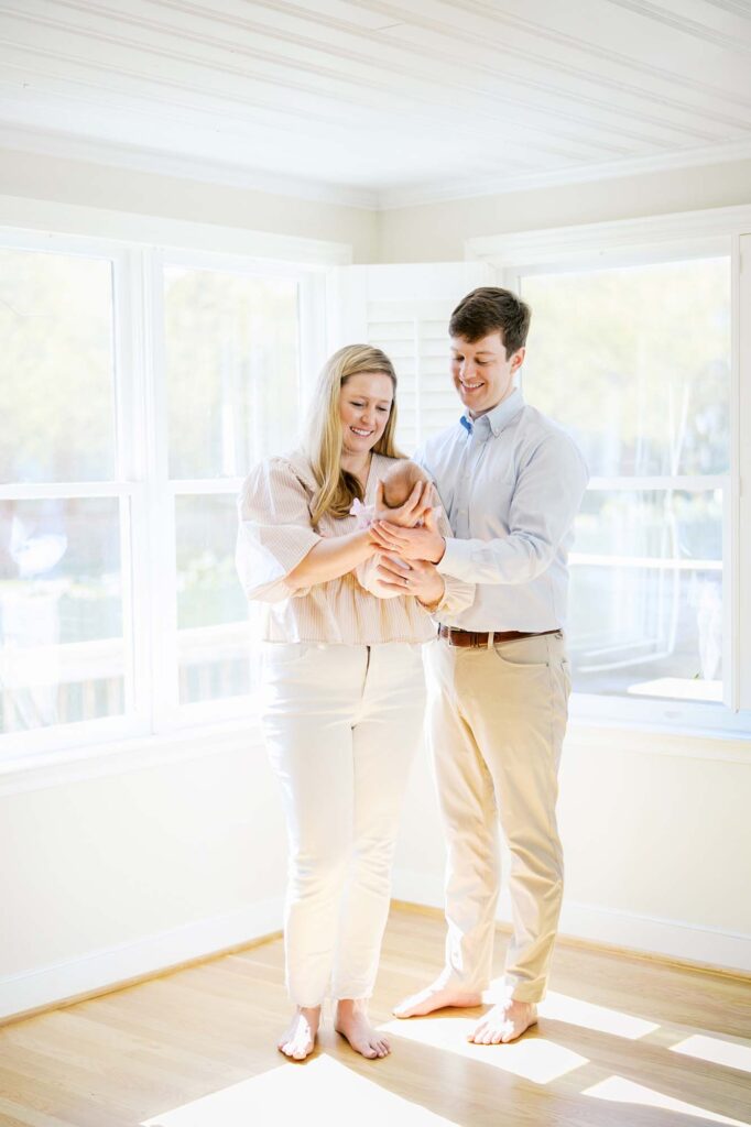 A mom and dad looking at their baby at the best time of day for newborn photos by Katie Stansfield Photography.
