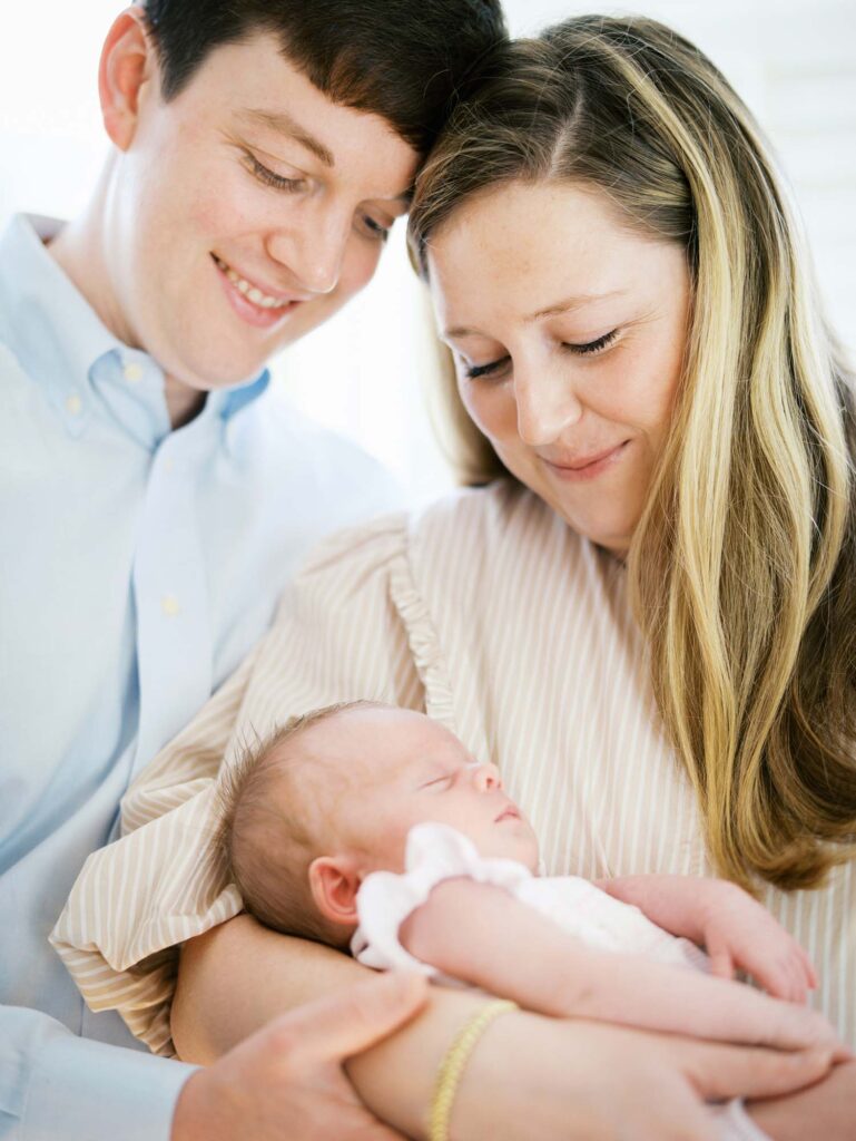 A mom and dad holding their baby at a newborn session by Katie Stansfield Photography.