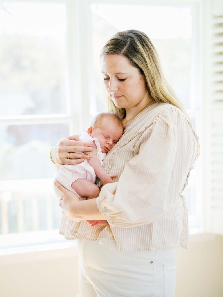 A mom holding her baby at a newborn session by Katie Stansfield Photography.