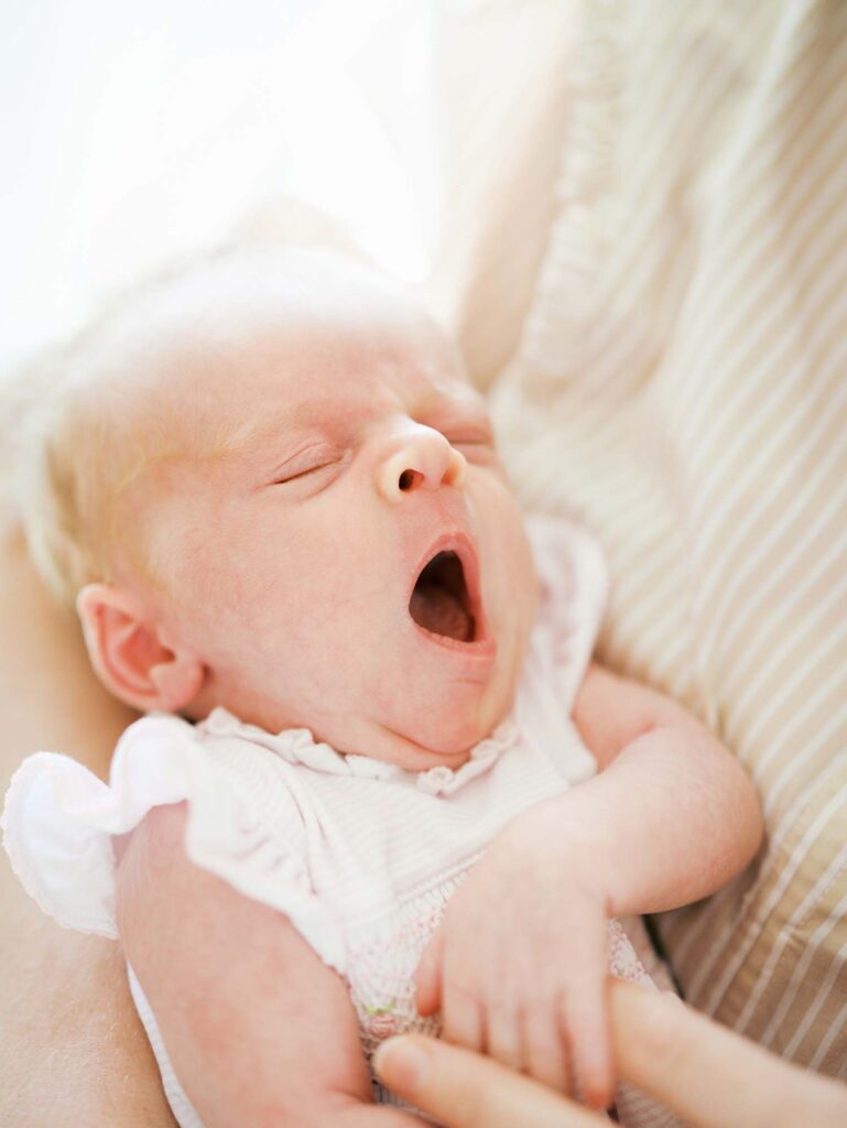 A baby yawning at a newborn session by Katie Stansfield Photography.