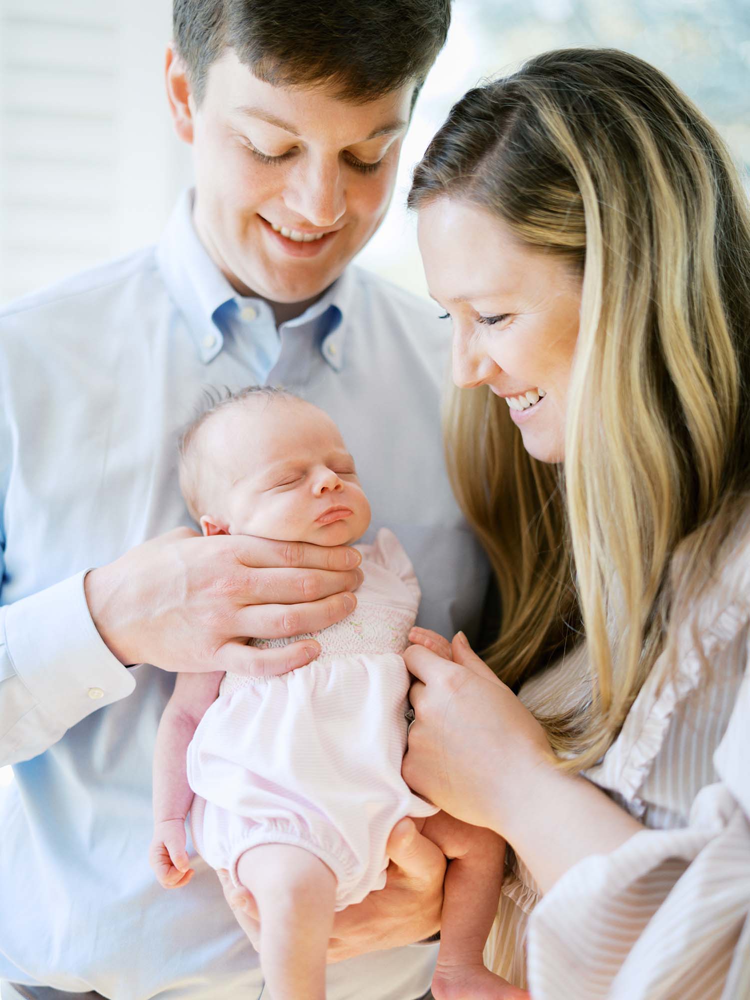 A mom and dad with their newborn at the best time of day for newborn photos by Katie Stansfield Photography.