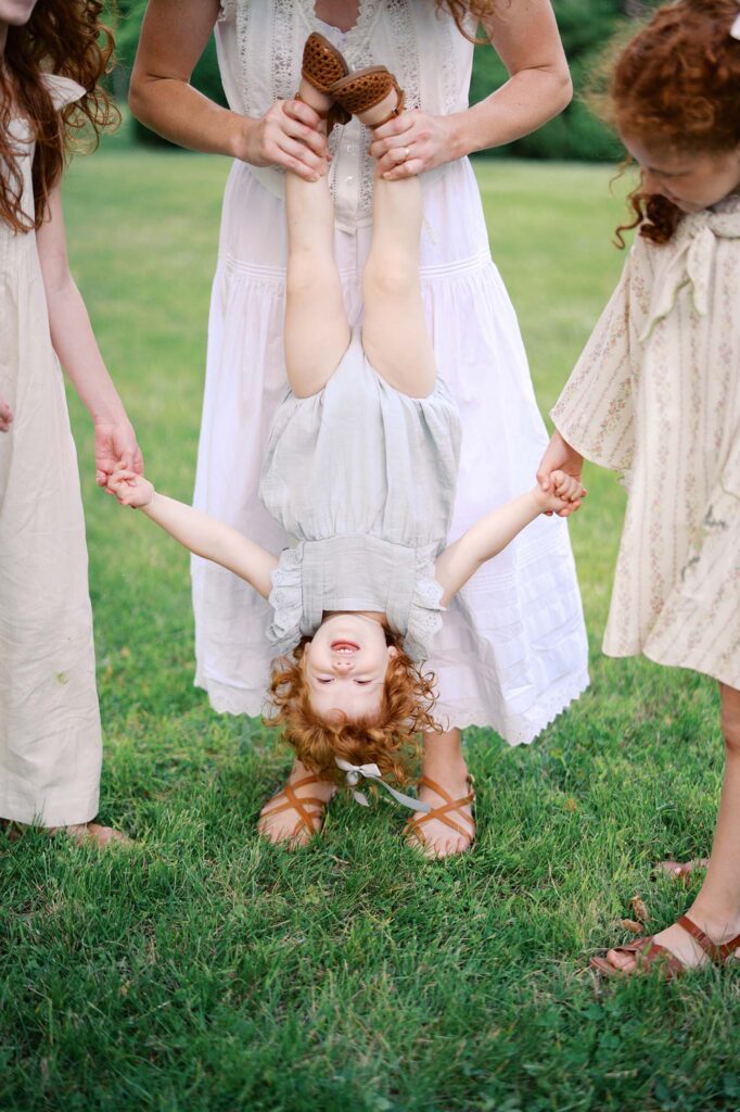 A mom holding her daughter upside down by Katie Stansfield Photography, a Glen Allen family photographer.