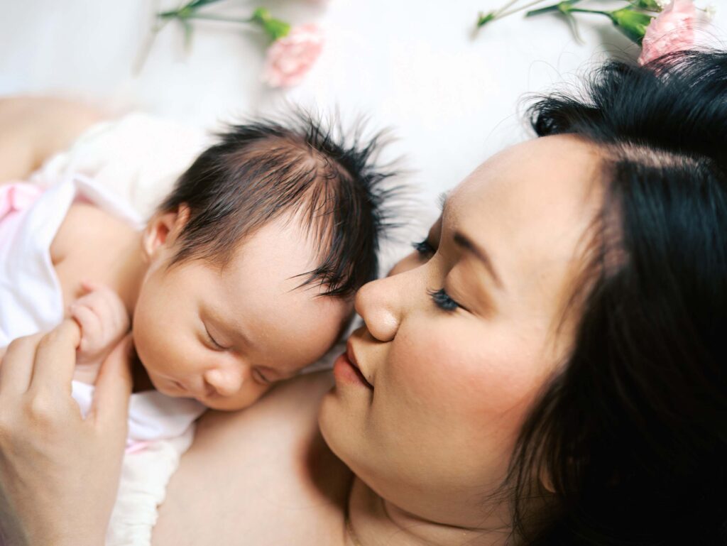 A mom and baby laying down together at an in-home session by Katie Stansfield Photography.