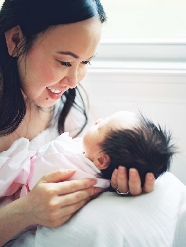 A mom smiling down at her baby at an in-home session by Katie Stansfield Photography, a Midlothian newborn photographer.