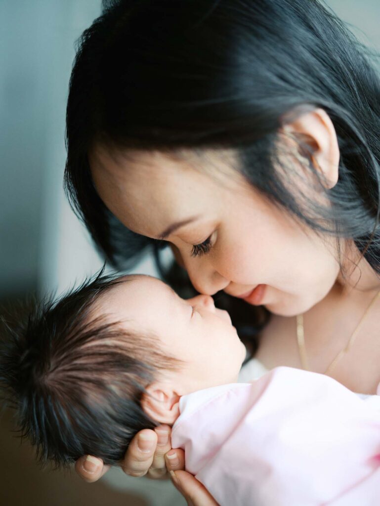 A mom and baby touching noses at an in-home session by Katie Stansfield Photography, a Midlothian newborn photographer.