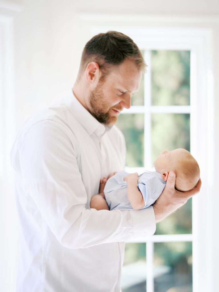 A dad looking down at his baby by Katie Stansfield Photography, an Ashland VA newborn photographer.