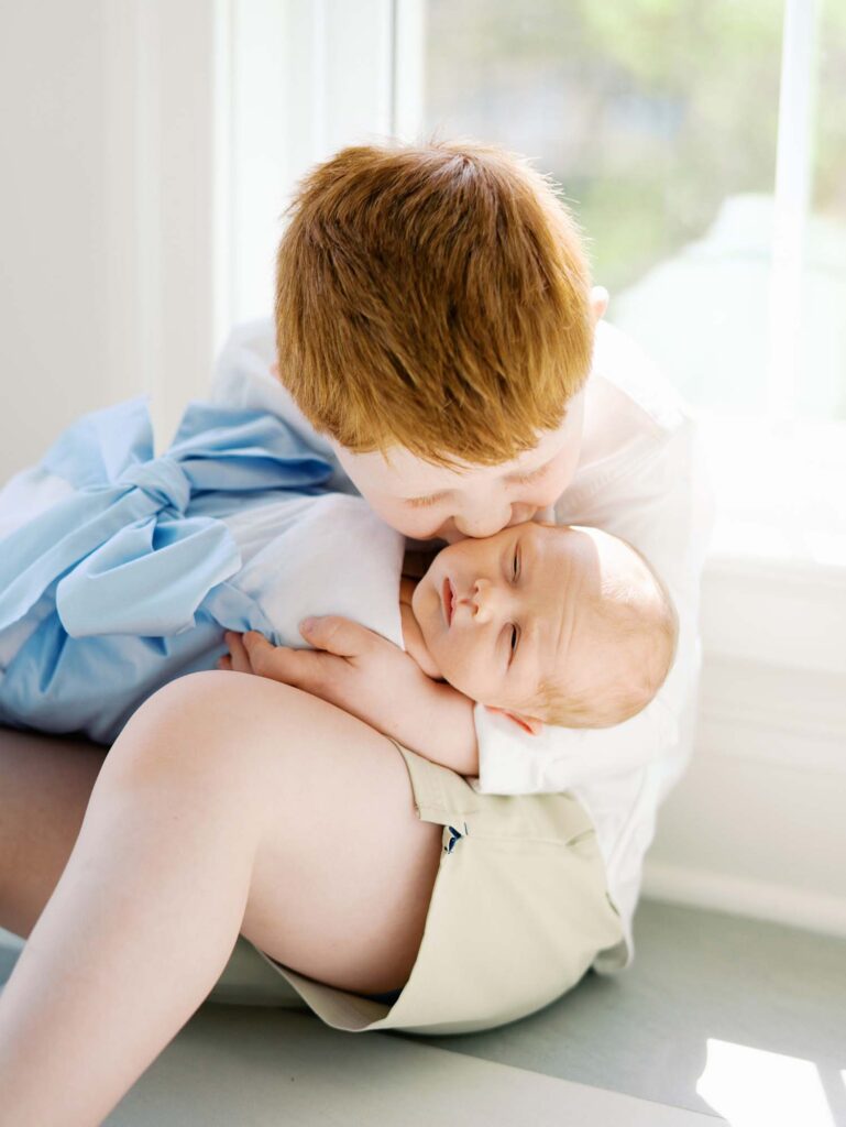 A young boy kissing his baby brother by Katie Stansfield Photography, an Ashland VA newborn photographer.