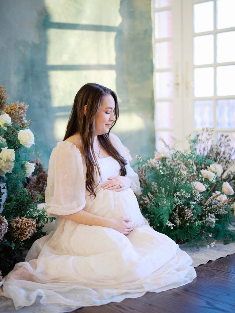 A mom holding and looking down at her baby bump at a maternity session by Katie Stansfield Photography, a Bon Air maternity photographer.