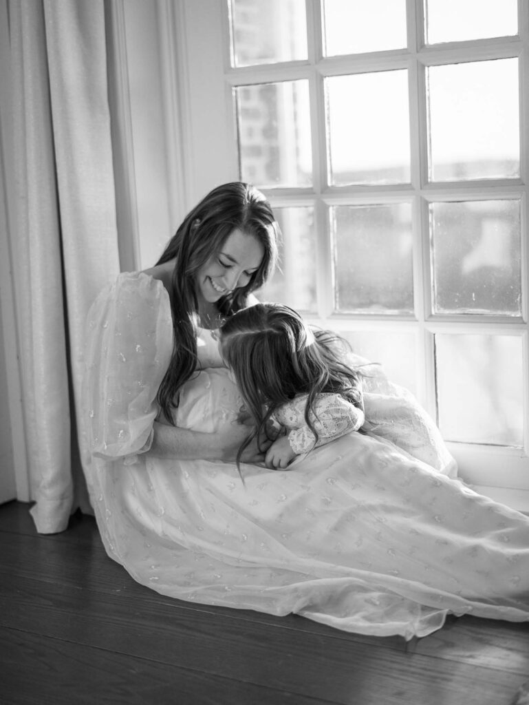 A mom and her daughter laughing at a maternity session by Katie Stansfield Photography, a Bon Air maternity photographer.