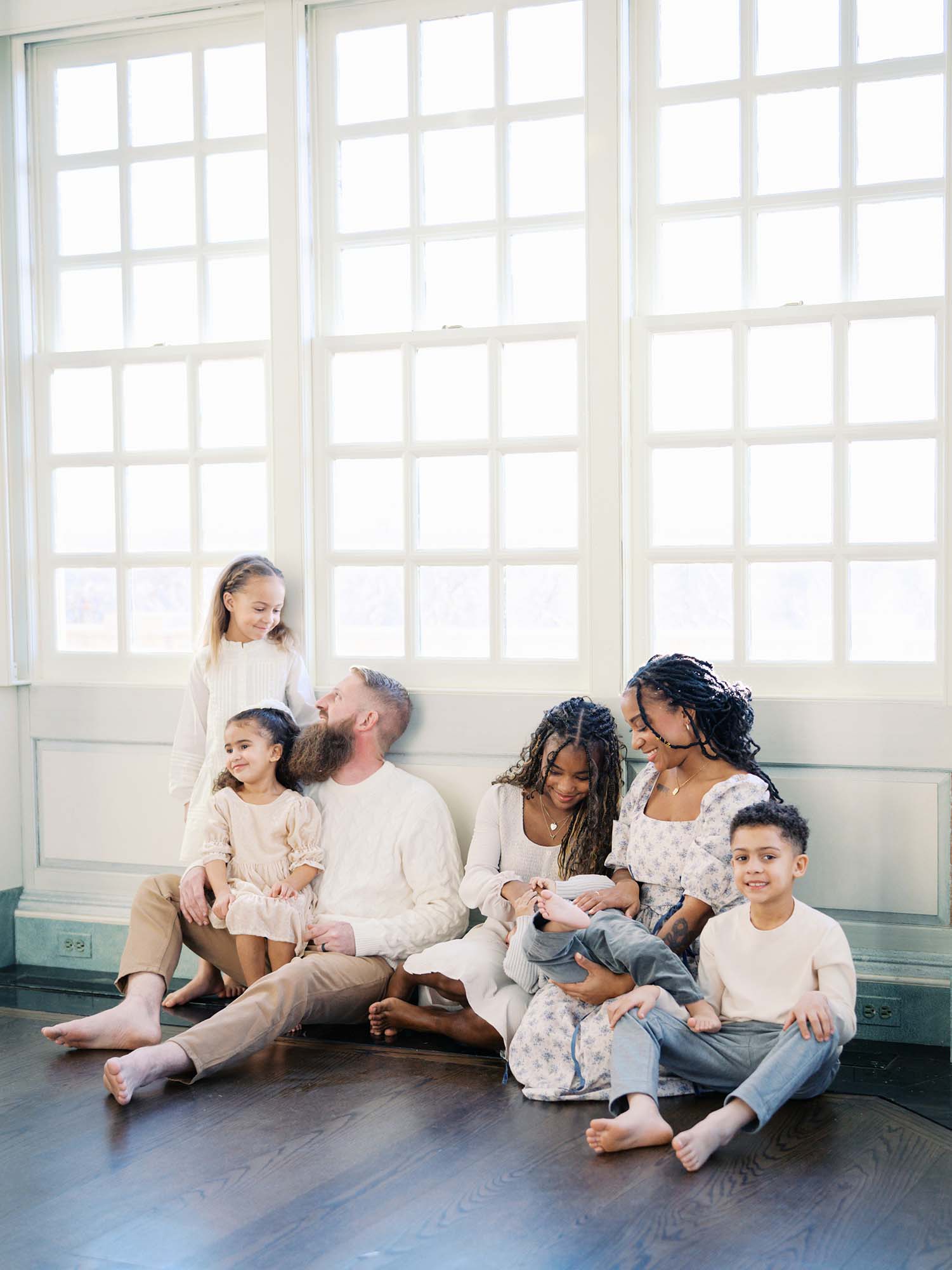 A family smiling at each other to show what to look for in a photographer for your family by Katie Stansfield Photography.