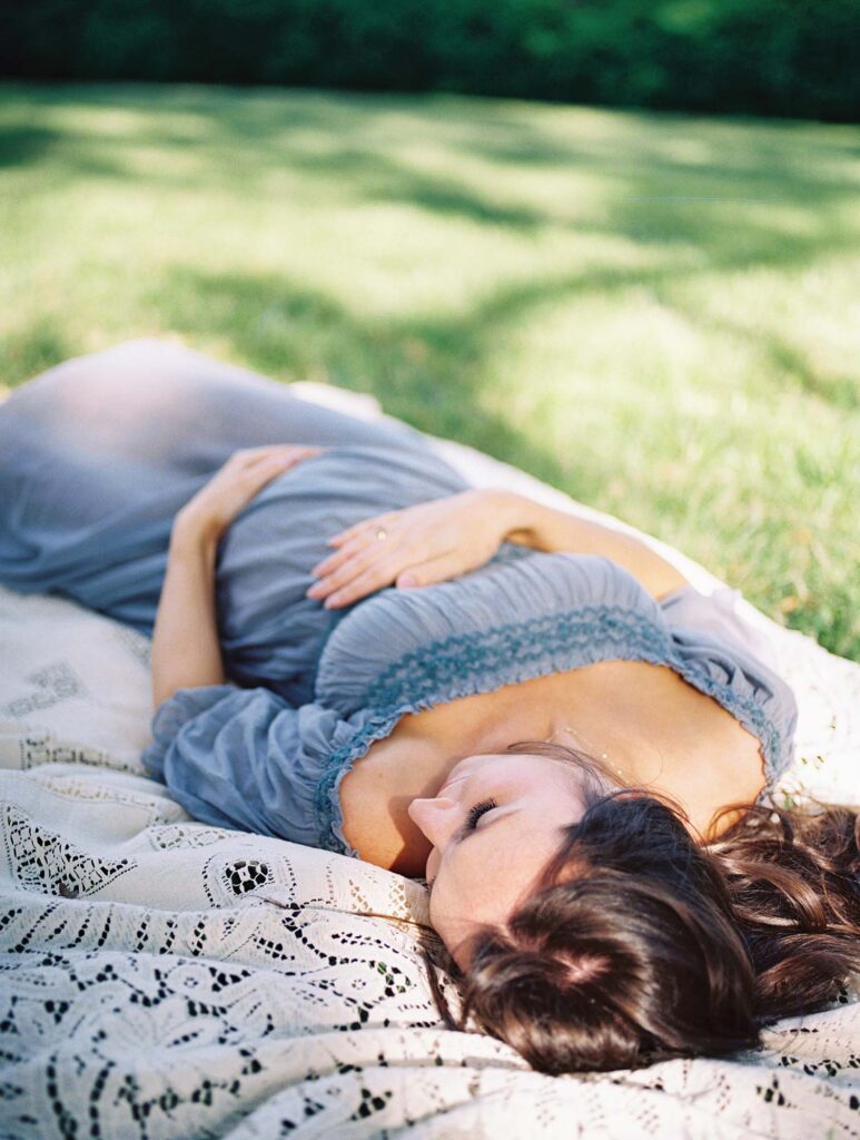 A mom laying down and holding her baby bump by Katie Stansfield Photographer, a maternity photographer in Henrico County, VA.