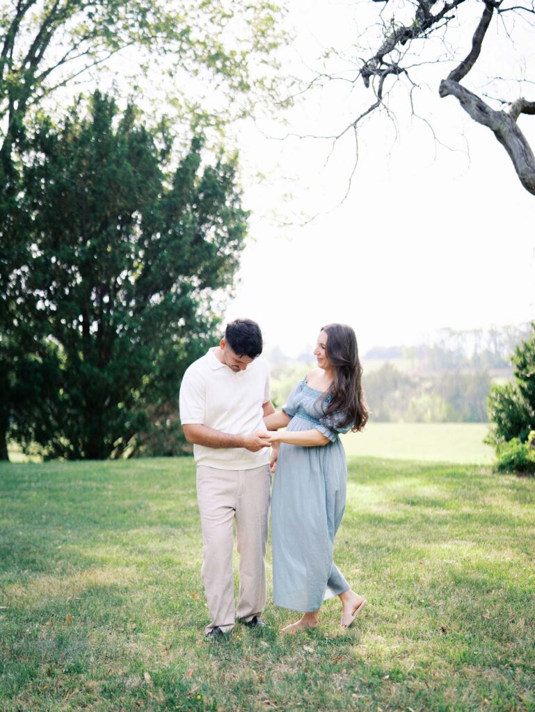 A couple smiling at each other at a maternity photo session by Katie Stansfield Photography.
