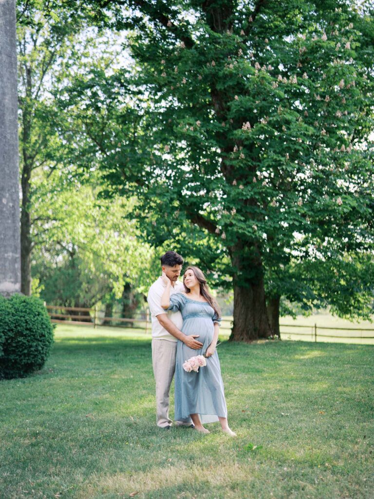 A couple looking at each other as mom holds her baby bump by Katie Stansfield Photography, a maternity photographer in Henrico County, VA.