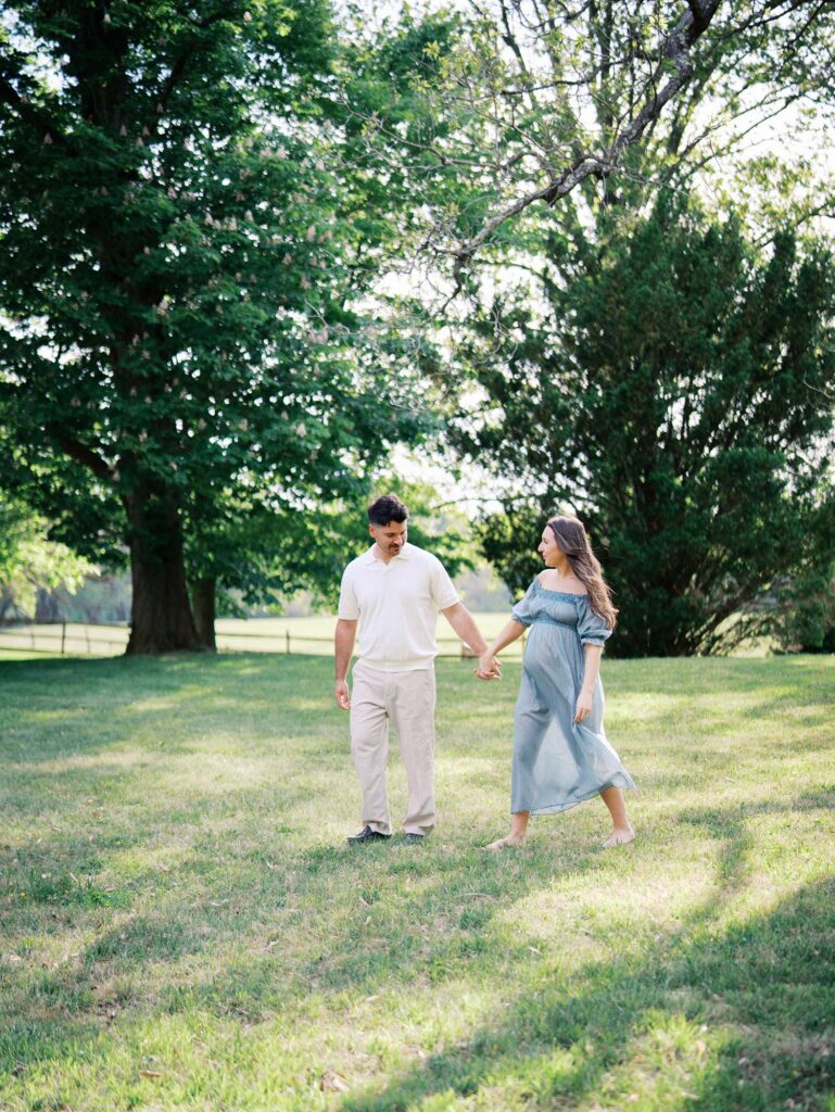 A couple holding hands and walking by Katie Stansfield Photography, a maternity photographer in Henrico County, VA.