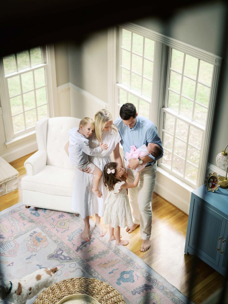 A family holding and looking at their baby in their home, one of the newborn photo locations in Richmond VA, by Katie Stansfield Photography.