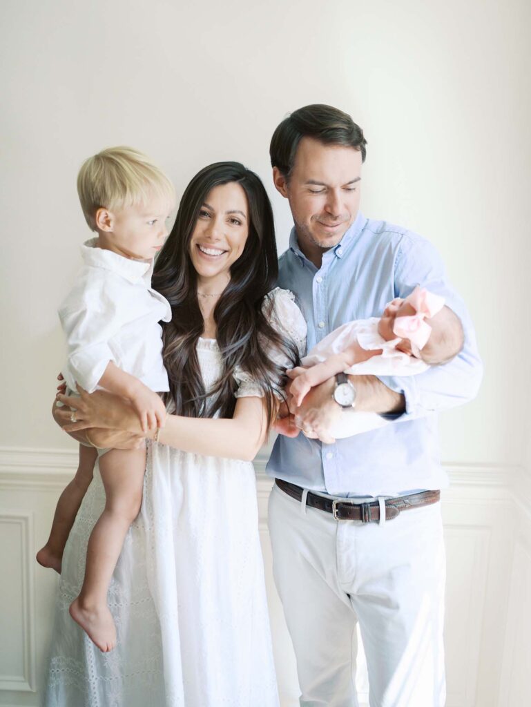 A family looking at a baby while mom smiles by Katie Stansfield Photography, a Bon Air newborn photographer.