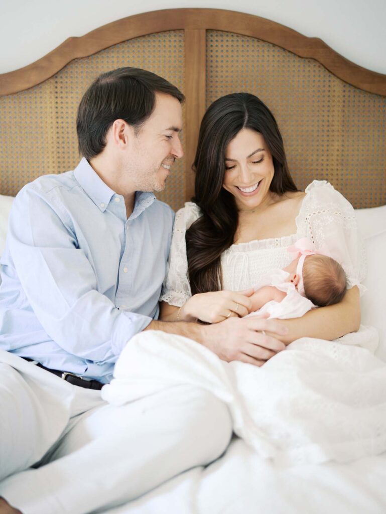 A mom smiling down at her baby as dad smiles at mom by Katie Stansfield Photography, a Bon Air newborn photographer.