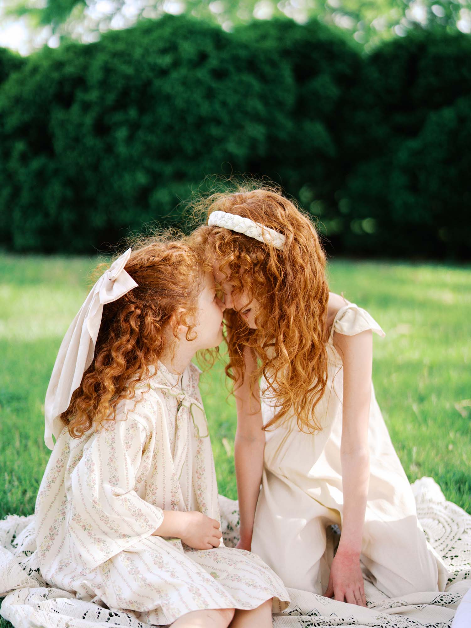 Two girls touching foreheads by Katie Stansfield Photography, a family photographer in Short Pump VA.