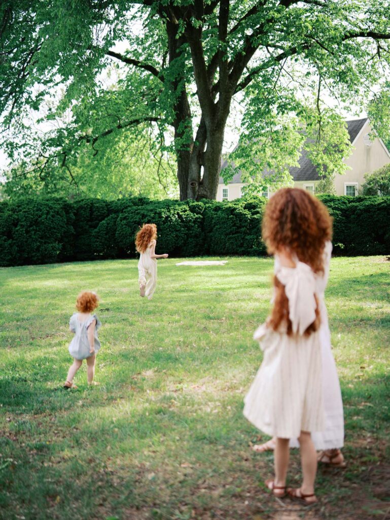 A mom and daughter looking at two daughters running ahead at a family session by Katie Stansfield Photography.