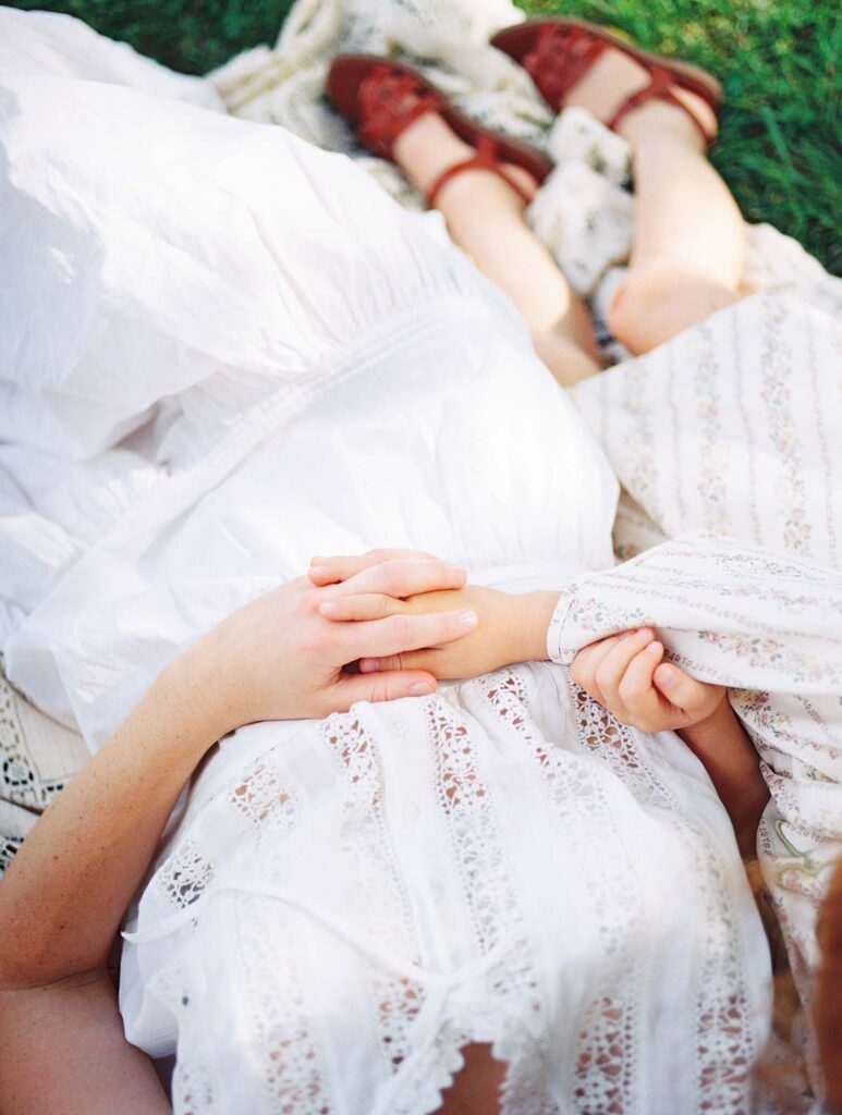 A close-up of a mom and daughter holding hands by Katie Stansfield Photography, a family photographer in Short Pump VA.