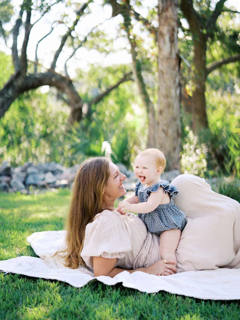 A baby sitting on mom at an at-home Chesterfield family photography session by Katie Stansfield Photography.