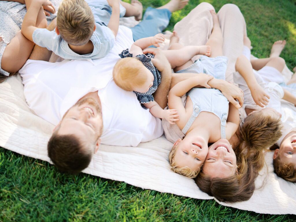 A family laying down and smiling at an at-home family session by Katie Stansfield Photography, a Chesterfield family photographer.