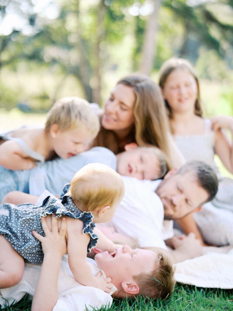 A family laying on a blanket at an at-home family photography session by Katie Stansfield Photography.