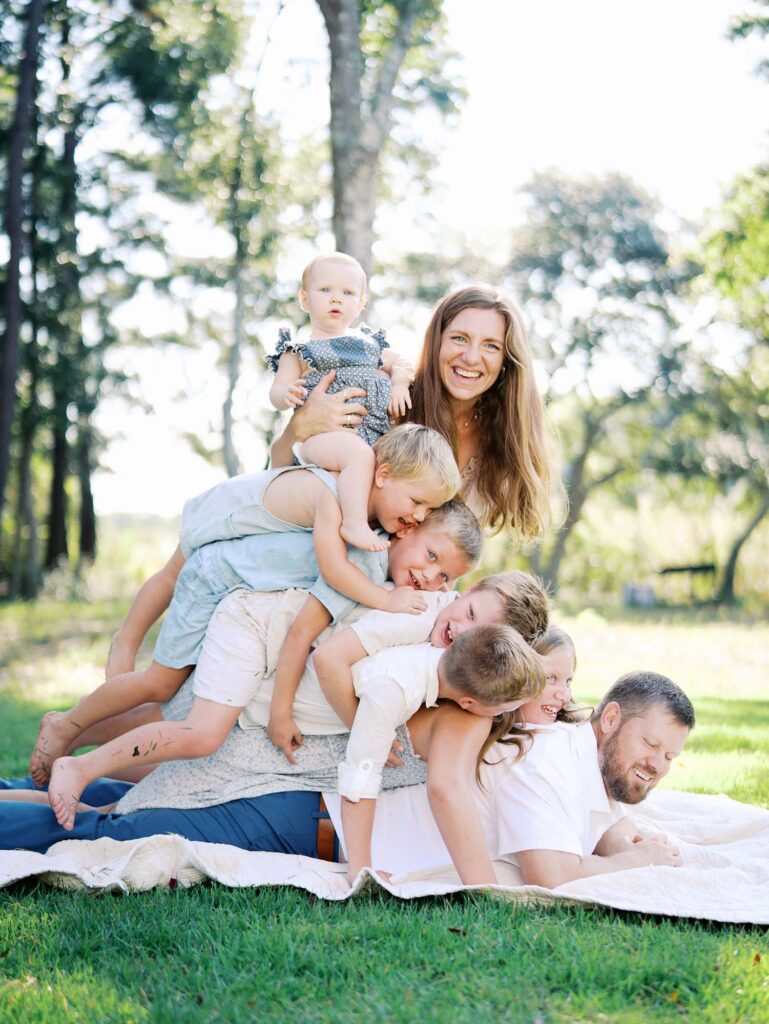 A family laying down stacked on top of each other at an at-home Chesterfield family photo session by Katie Stansfield Photography.