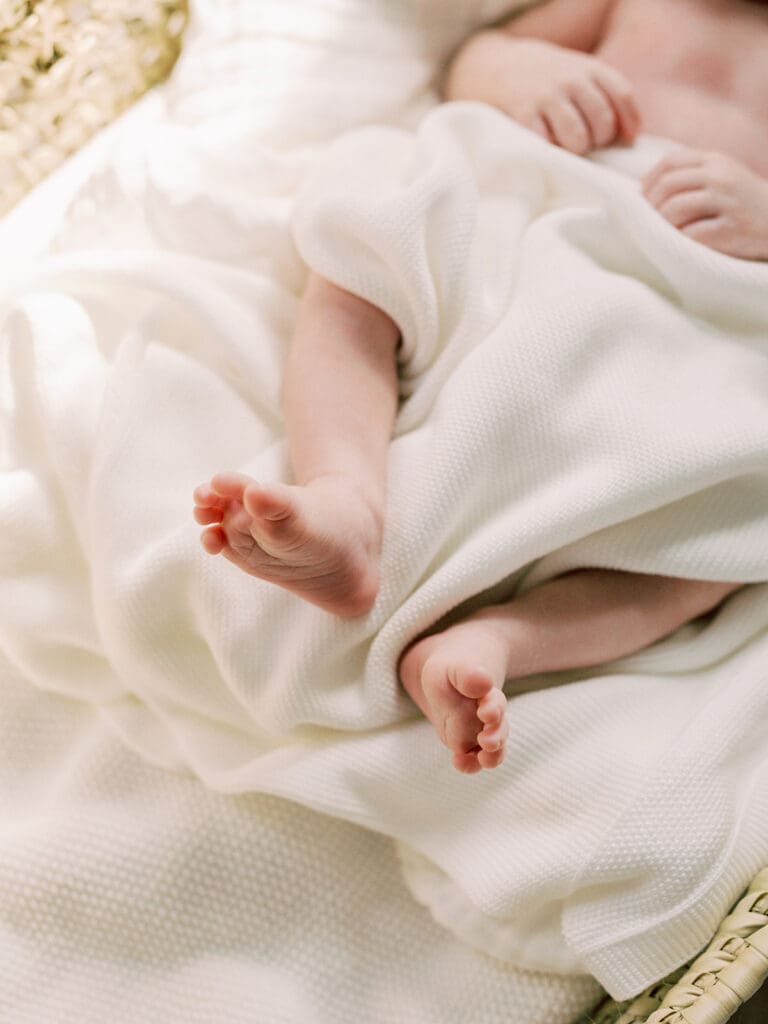 A close-up of a baby's feet while the baby is wrapped in a blanket at a Richmond in-home newborn photography session by Katie Stansfield Photography.