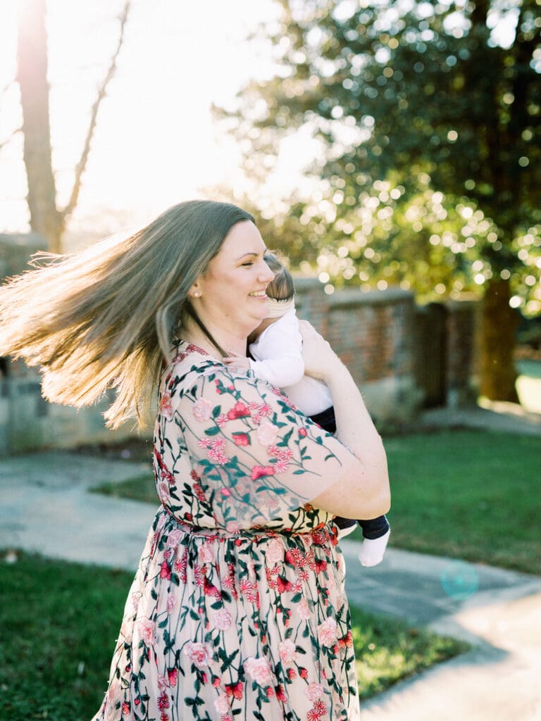 A woman smiling while holding her baby at a Richmond family photography session by Katie Stansfield Photography.