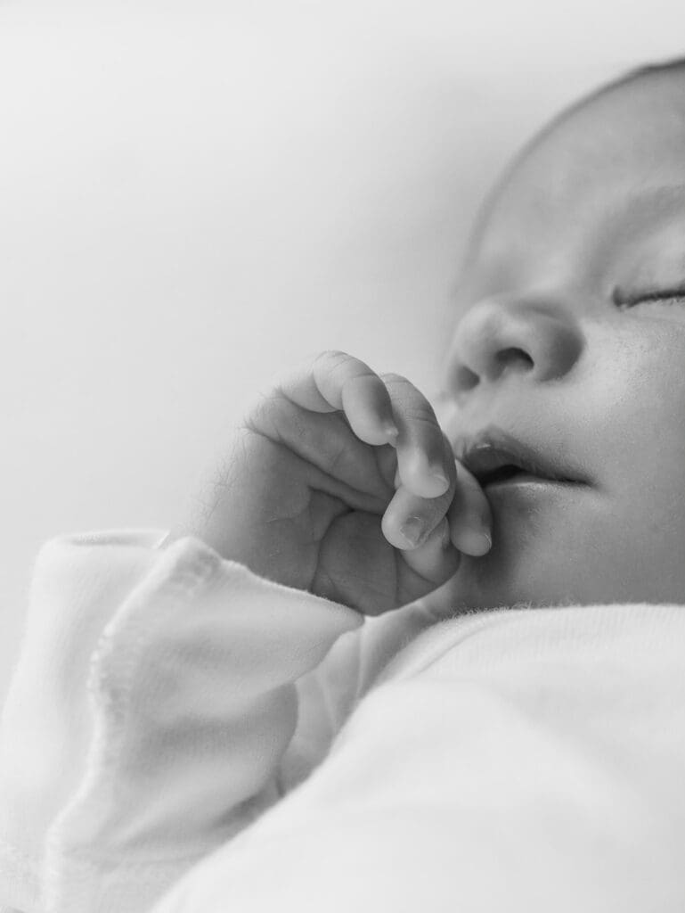 A close-up of a baby's hand while the baby is sleeping during a session by Katie Stansfield Photography, a Chesterfield newborn photographer.