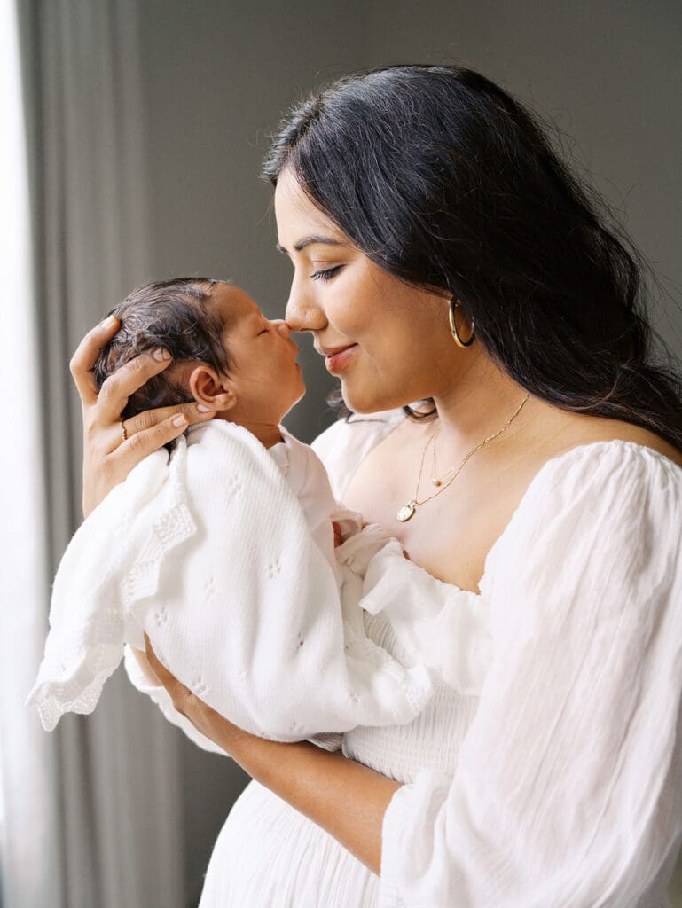 A mom touching noses with her baby during a session by Katie Stansfield Photography, a Chesterfield Newborn Photographer.