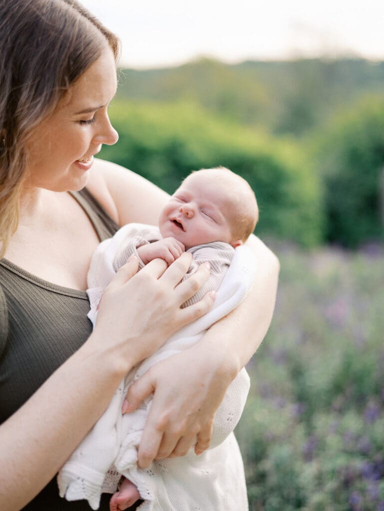 A mom holding a two-week old baby at a newborn session by Katie Stansfield Photography.