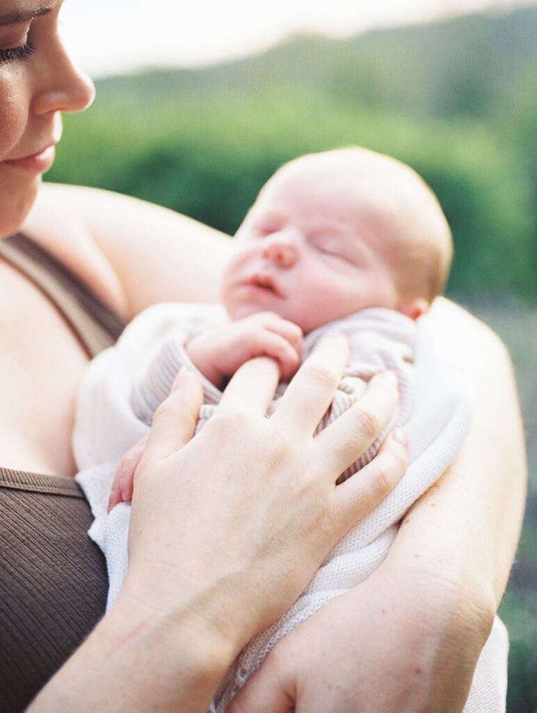 A close-up of a baby held in mom's arms during a newborn session by Katie Stansfield Photography.